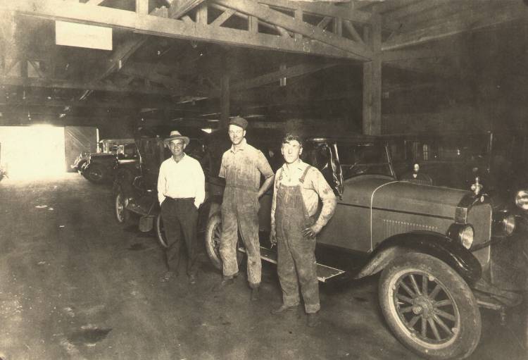 John H. Fiegenbaum and two other men in the garage at L & L Auto Supply