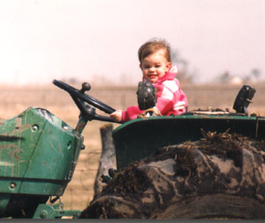 photograph of a young Katherine Heath Fiegenbaum driving a tractor