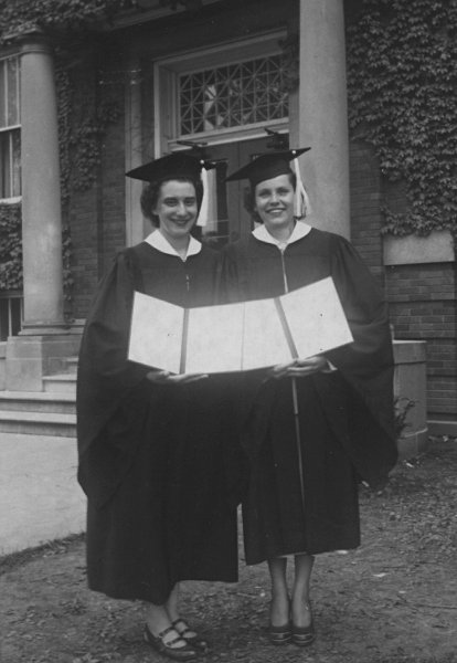 a photograph of Dorothy Gerber and an unidentified friend in their graduation robes displaying their diplomas from Elmhurst College