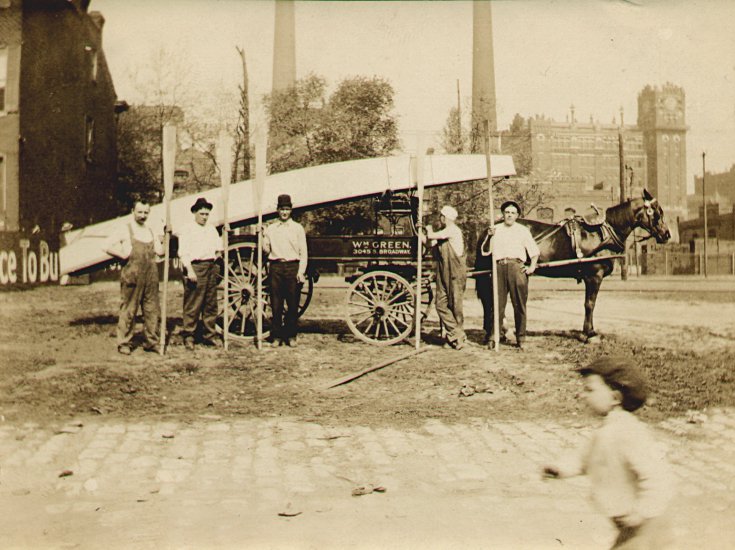 photograph of Eugene Gerber and friends posed with oars in front of a horse and wagon loaded with a boat
