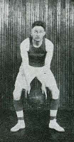 photograph of Arthur W. Starkebaum dressed in his basketball uniform taking a shot